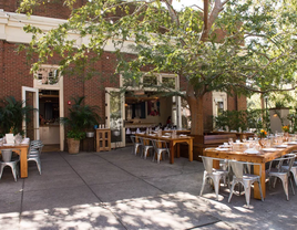 Dappled sunlight peeks through the trees to fall on this gorgeous event space at Le Farfalle.