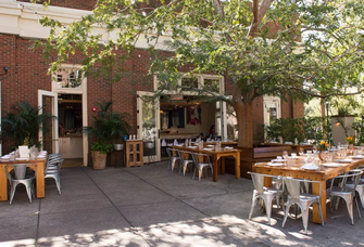 Dappled sunlight peeks through the trees to fall on this gorgeous event space at Le Farfalle.