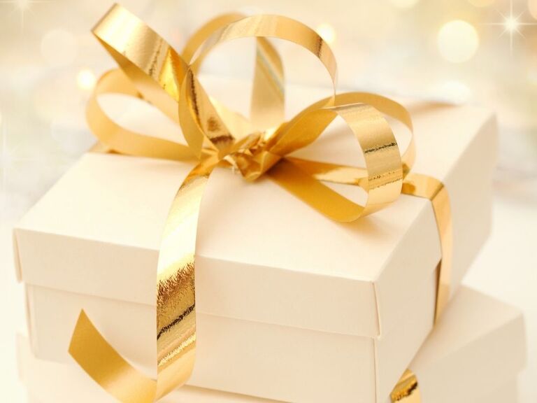 white gift box wrapped in gold ribbon