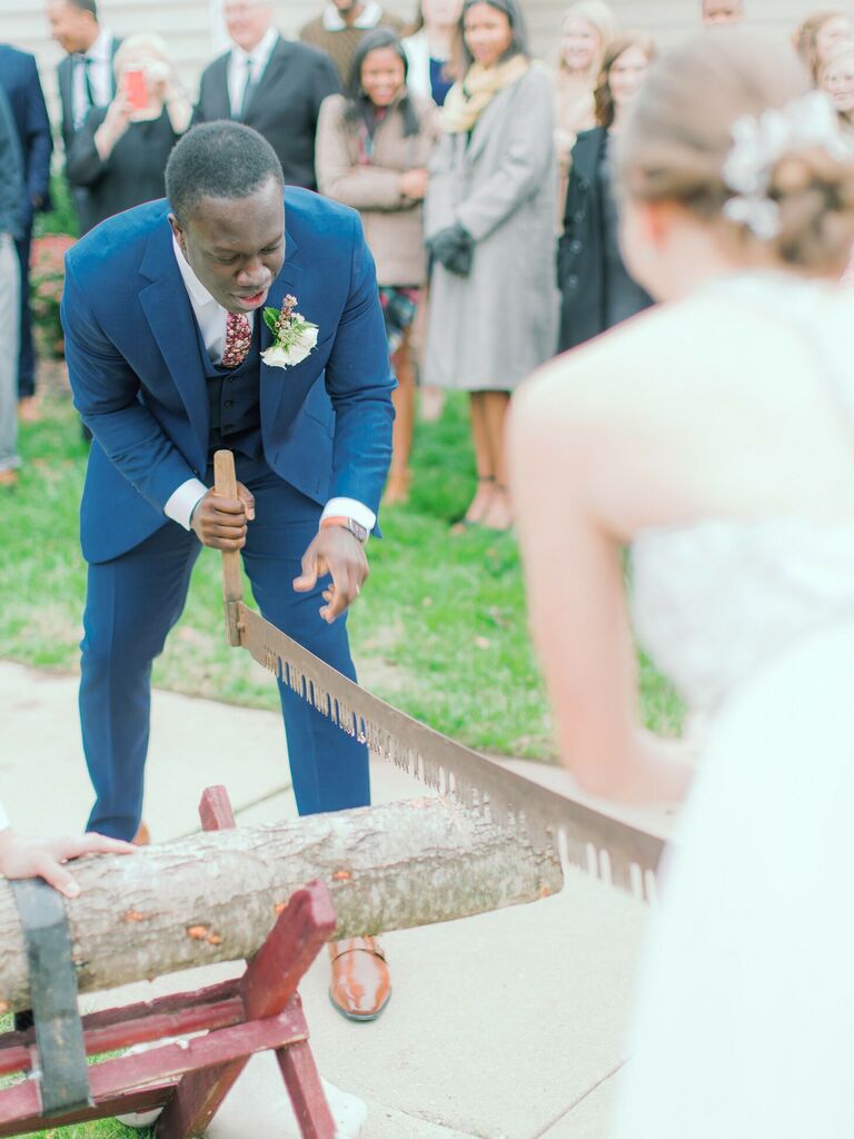 Couple sawing log during wedding ceremony