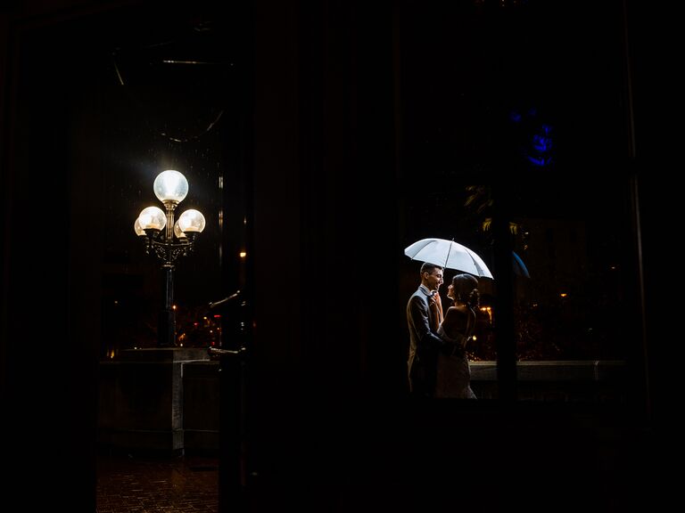 Couple hugging under umbrella