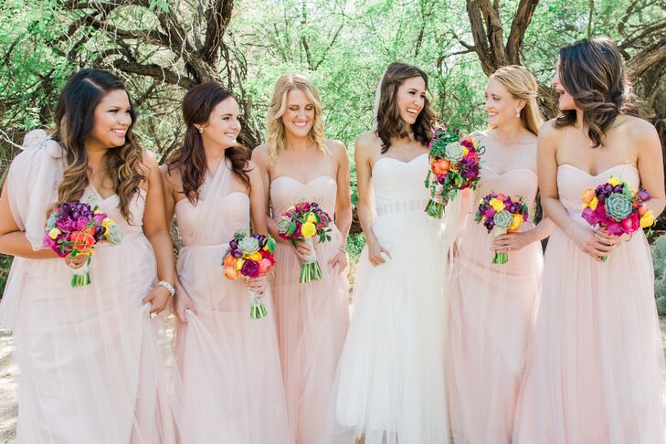 Kelsey's bridesmaids donned floor-length, tulle dresses that were a very light dusty rose. "The dress had tulle straps that could be fashioned in a number of ways, so they could all customize their dress to their body type and desire," she says.