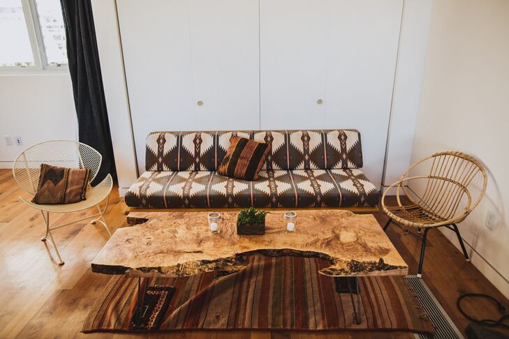 An ivory and brown couch with a tribal pattern was positioned next to two chairs, one made of wood and one made of wire. The furniture was arranged around a table made of wood, which looked like it was carved right out of a tree. The furniture molded perfectly with the rustic, desert theme of the wedding.