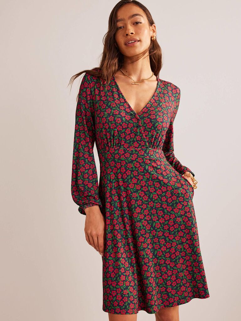 Model wearing a jersey dress with a red and green floral print