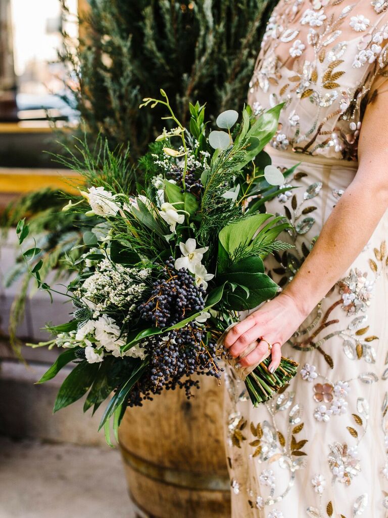 elegant fall wedding bouquet with white flowers, greenery and dark blue berries