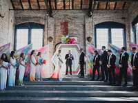 Bride and groom getting married at colorful wedding ceremony in rustic building