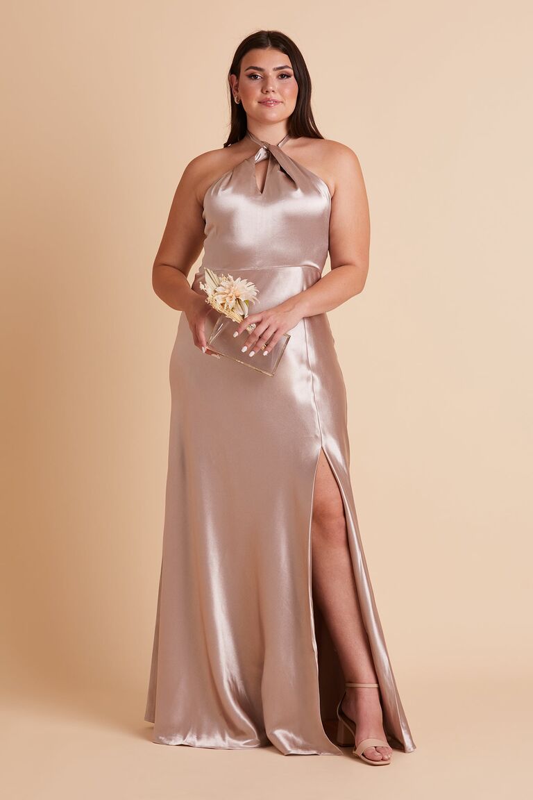Model wears a silk gown with a high neckline and a slit on the side. 
