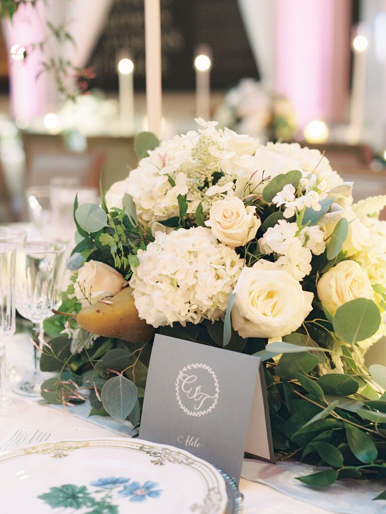 classic low wedding centerpiece with white hydrangea, cream roses, stock and eucalyptus