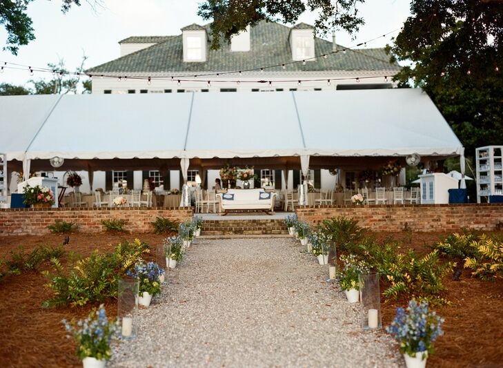 Kathryn and Cal held their reception under a large white tend overlooking the Ashley River. Strings of bistro lights and pillar candles added ambient charm to the outdoor space as the sun started to set.