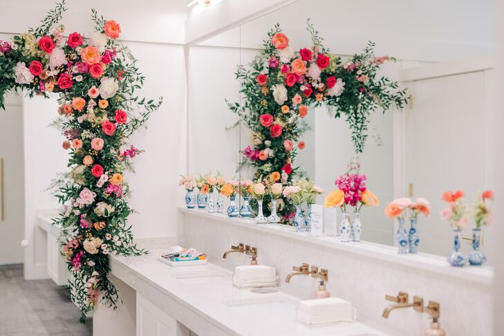 A wedding reception bathroom filled with blush, coral and white flower arrangements including hanging florals.