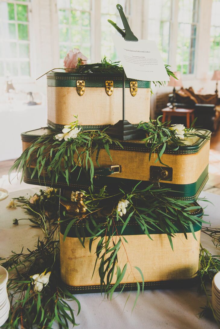 At the reception, a display of yellow and green pieces of luggage were stacked on one another, reflecting the vintage twist within the wedding decor. The luggage was draped with greenery and positioned in the middle of the room.