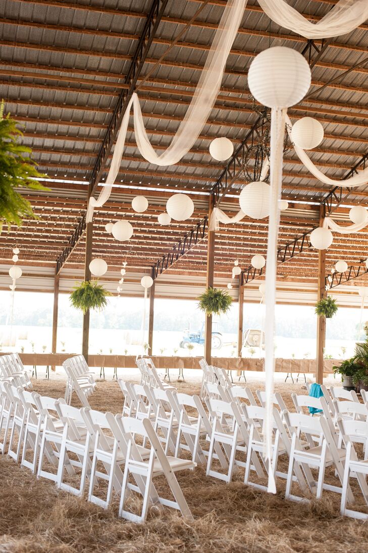 "The white decor represents the pure and natural love we have for each other," Lauren says. Guests sat in white folding chairs under white drapery and paper lanterns hanging from the barn ceiling.