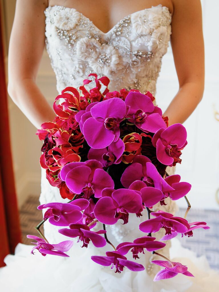 round wedding bouquet with red lilies and purple orchids cascading down the front