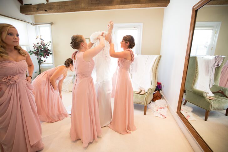Bridesmaids in Floor Length Blush Dresses Helping the Bride