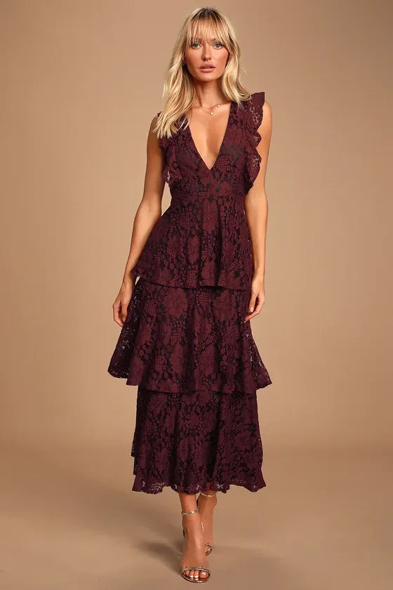 Model wears a burgundy dress with a plunging neckline and ruffled detailing. 
