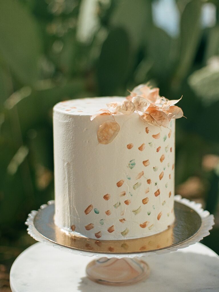 rustic boho one tier wedding cake with abstract brush stroke design and dried greenery on top