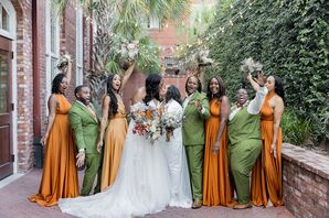 Two Brides With Bouquets Kissing Between Wedding Party in Orange and Green