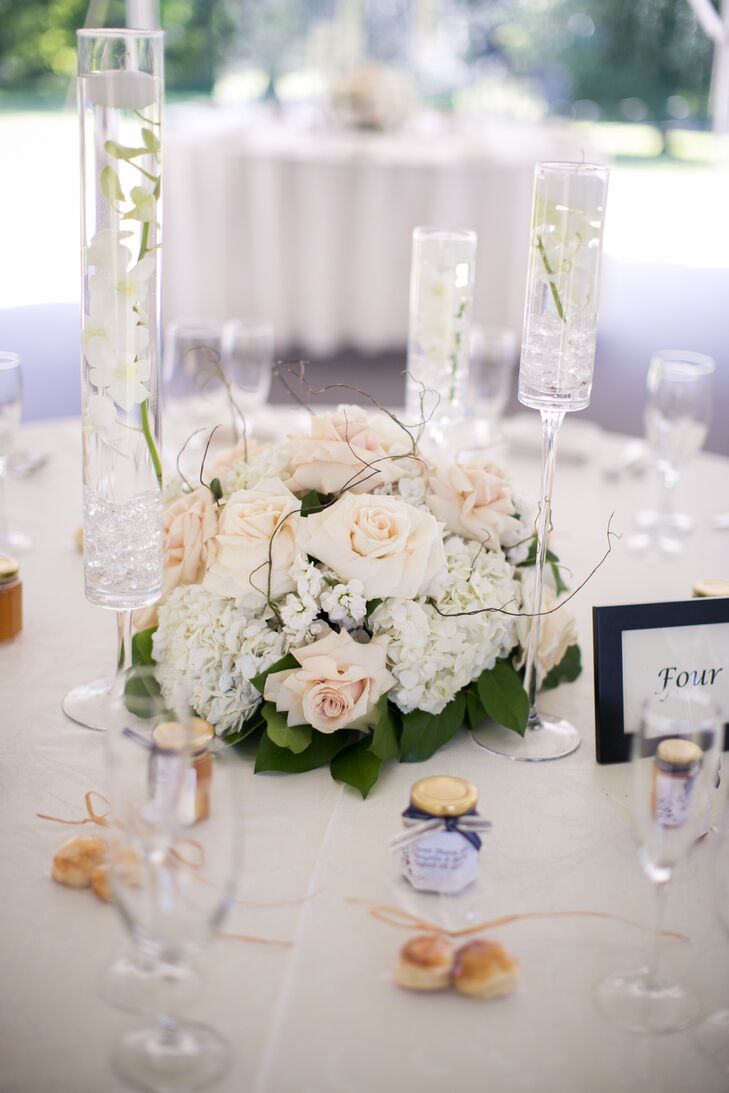 Reception centerpieces alternated between tall and short floral orchid centerpieces, which included blush roses. Tall glass vases were filled with floating flowers.