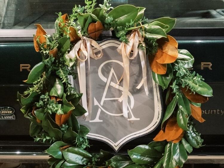 Magnolia leaf wreath with monogram sign on vintage getaway car