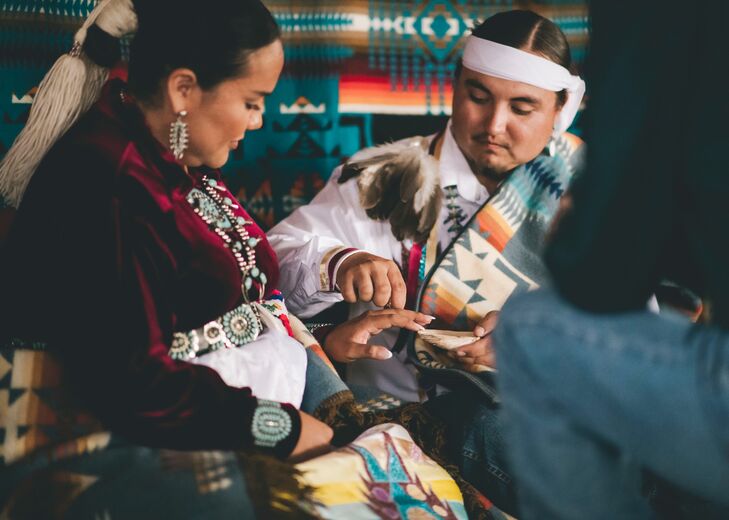 Groom Puts Wedding Ring on Bride's Finger During Traditional Native American Navajo Wedding Ceremony
