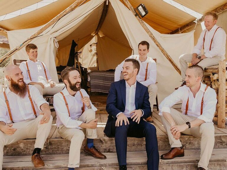 Groom in navy suit with groomsmen in casual boho slacks and rust-colored suspenders