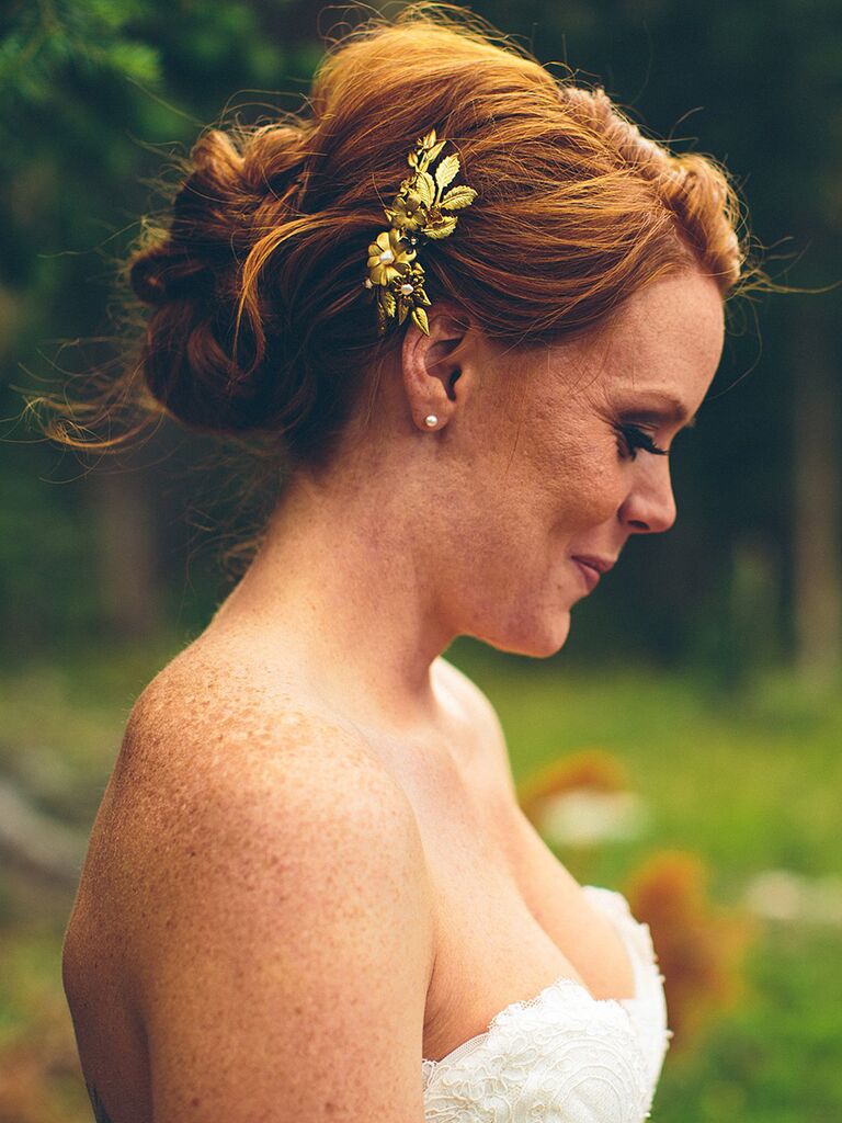 Messy bun wedding updo with a hairpiece