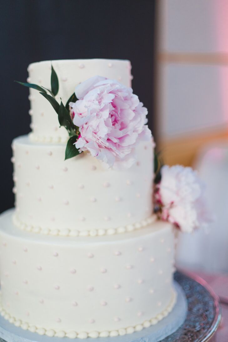 Swiss dots on this white buttercream cake felt timeless, just like Melissa and Matt’s wedding. A pair of blush peonies and an elegant silver cake stand dressed up the style.