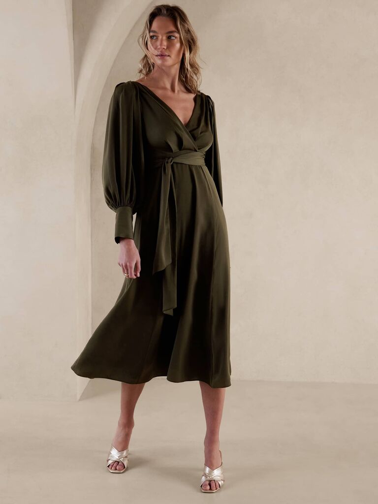 Model wearing an olive-colored long sleeve dress with a waist tie 