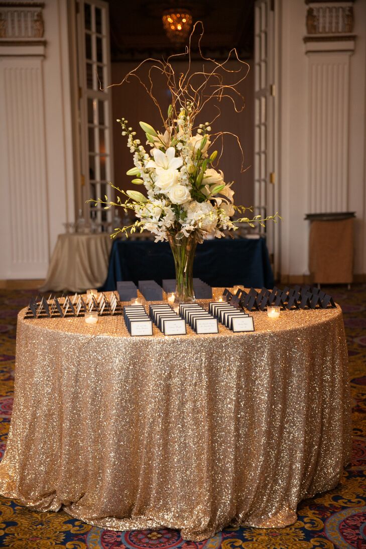 The ornate white and gold interior of Fairmont Copley Plaza in Boston, Massachusetts, played into their theme of timeless elegance. The couple's navy and gold escort cards echoed their invitations.