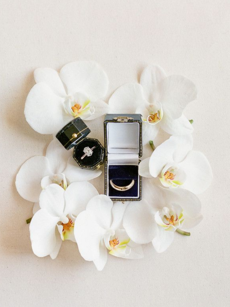 Engagement ring flat lay with white phalaenopsis orchids