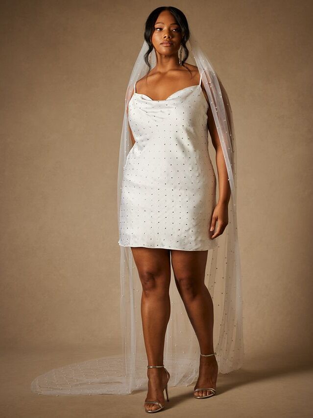 Model wears a mini dress with sparkling embellishments. 