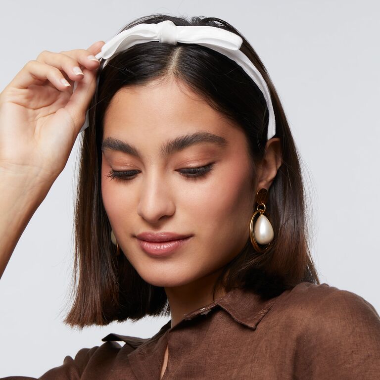 White bow headband by Lele Sadoughi. 