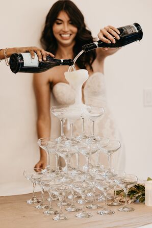 Pouring Champagne onto Tower of Glass Coupes