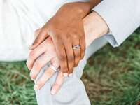 Couple holding hands showing off wedding and engagement rings