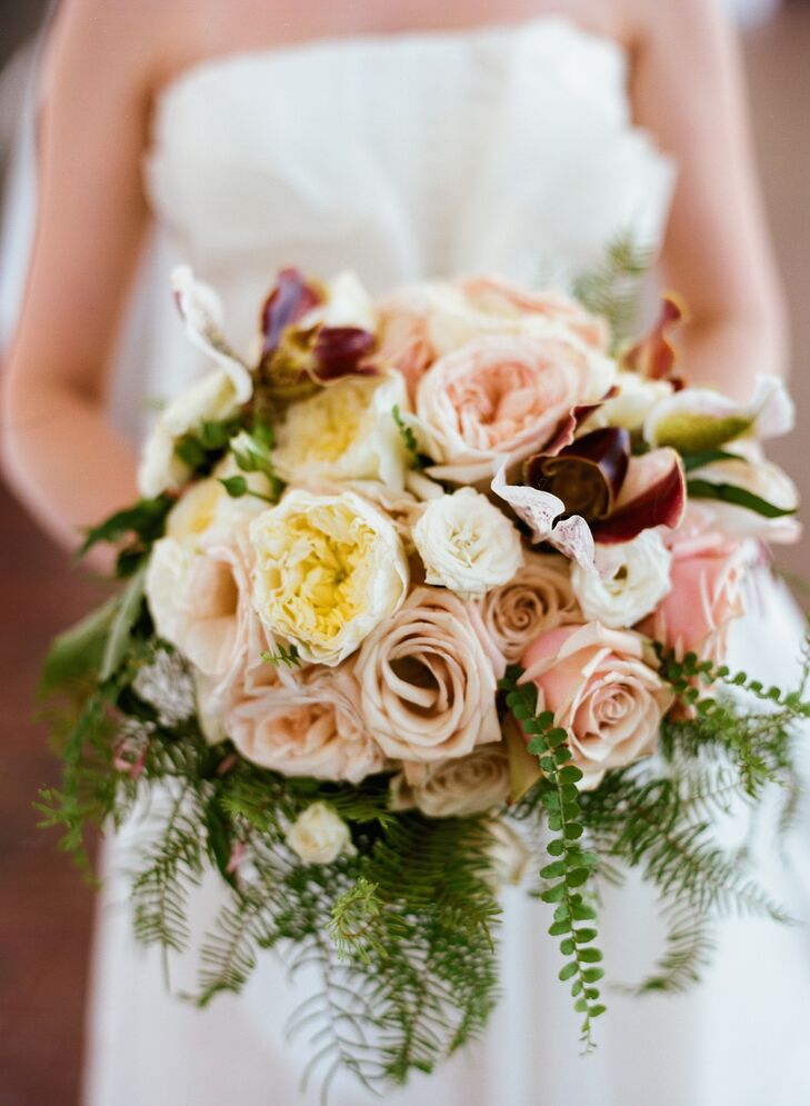 Martha's Gardens created all the floral arrangements. Garden roses, orchids, lisianthus and ferns filled Tessa's bouquet for a textured look that went with the rustic theme.