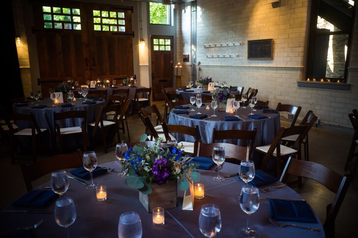 The loft reception featured round dining tables covered in navy linens. The space was illuminated with votive candles on all the tables.