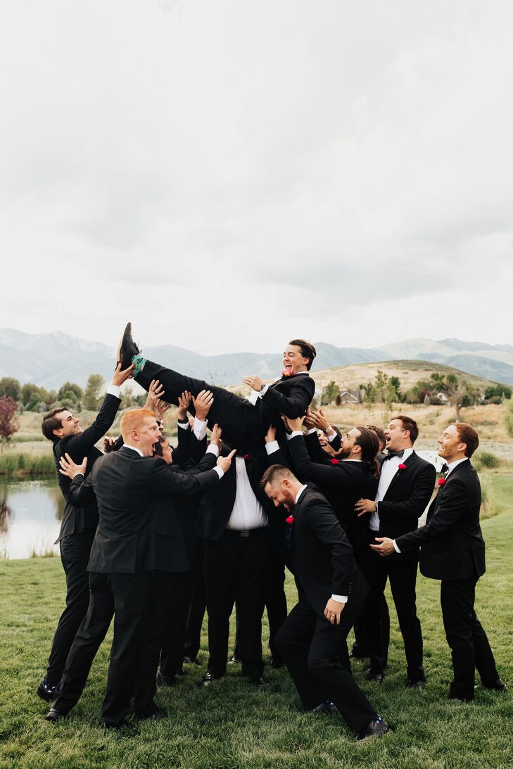 Groomsmen Throwing Groom in Air During Portraits