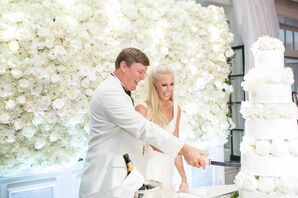 Cake Cutting Against White Flower Wall