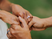 Couple holding hands with engagement ring on