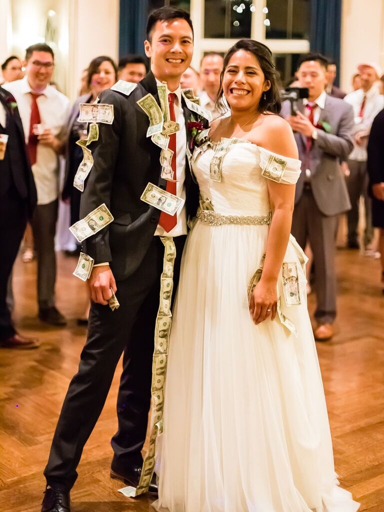Couple smiles at the camera after their traditional money dance. 