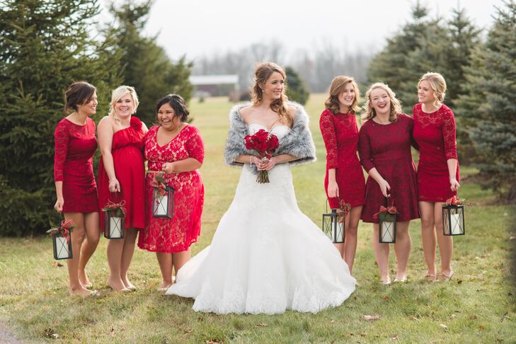 Elizabeth's six bridesmaids wore mismatched knee-length red bridesmaid dresses while carrying rustic lanterns down the ceremony aisle instead of bouquets.