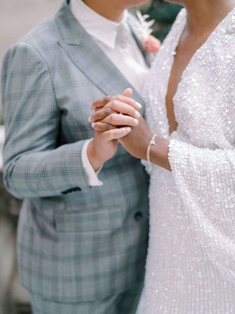 The happy couple dance together in grey and silver wedding attire