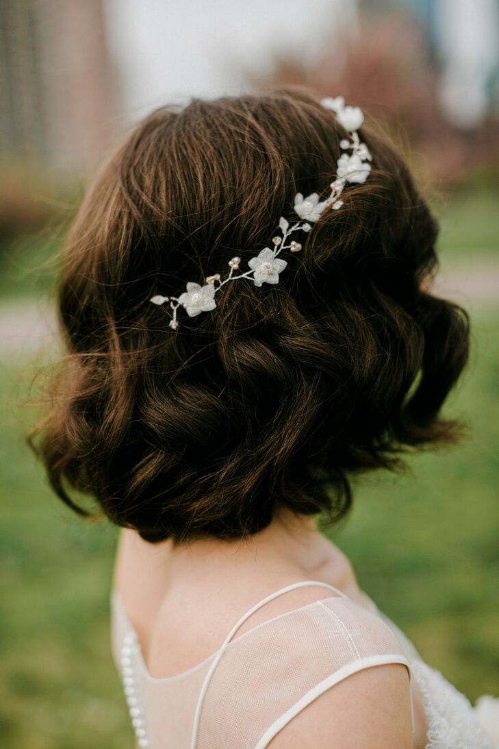 “I cut my hair the morning of the wedding. When Charlie and I met, my hair was pretty short and he loved it that way. So shortly after we got engaged, I decided I would surprise him and cut it for the wedding,” Janel says. “I cut off over 12 inches and donated it. No one at the wedding could believe I had actually cut my hair. They thought it was a faux bob.” To highlight her freshly cut locks, the team at Bumble and Bumble slipped a chic white floral headband onto her hair. Delicate pearl beading marked the leaf-inspired accents.