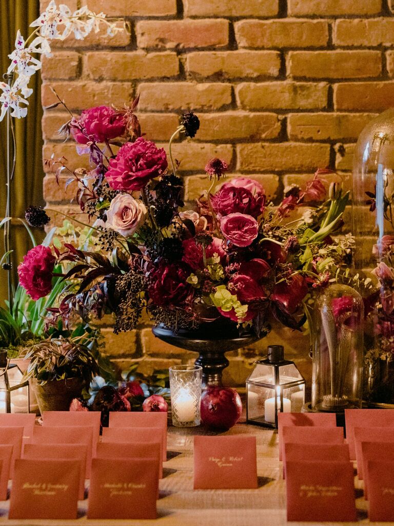 Letter and envelope escort card display with large floral arrangement