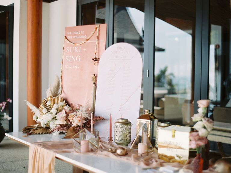 boho wedding gift table with arched wedding seating chart, gold acrylic card box, dried flowers and pink taper candles