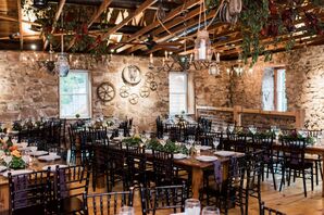 Rustic Reception Space with Black Chiavari Chairs and Hanging Greenery