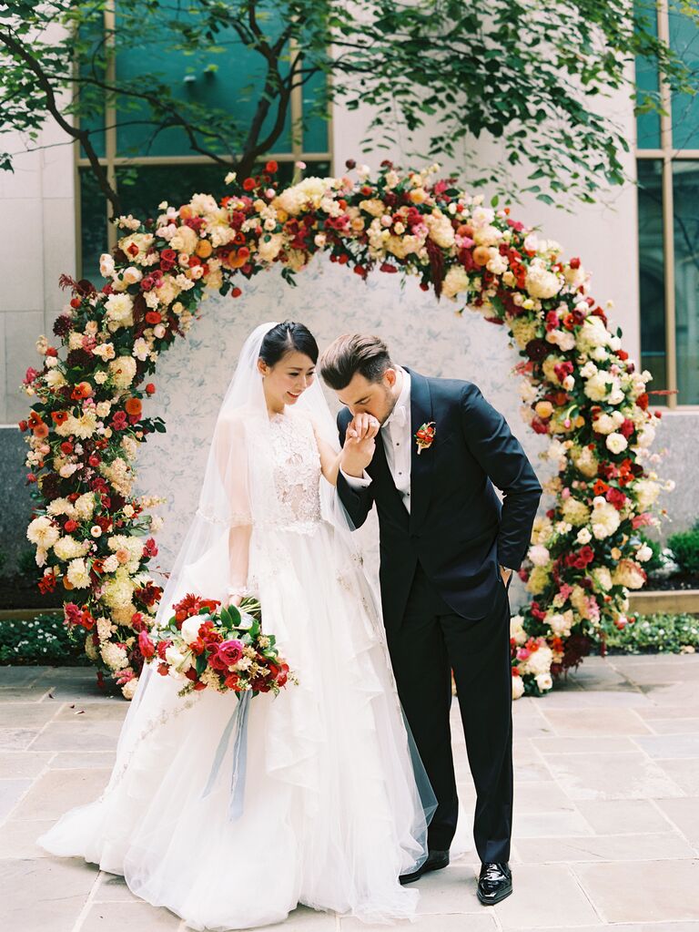 Groom kissing bride's hand