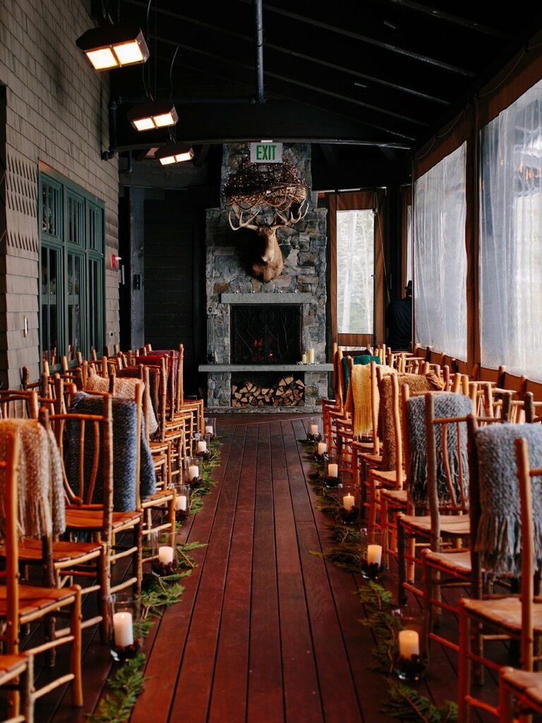 rustic wedding fireplace decor idea with moose head and stacked wooden logs at cozy indoor mountain venue 