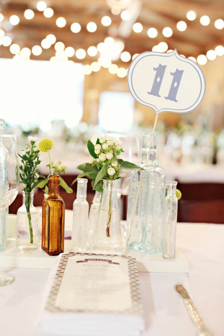 The bride printed the table numbers in a font that matched the rest of the stationery, and attached the numbered cards to long wooden skewers inside glass bottles.