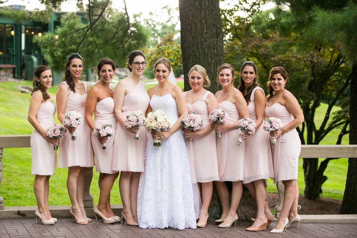 The couple's blush-colored flower arrangements were created to match the pale pink shade of each Bill Levkoff bridesmaid dress. In search of a simple yet classic look, Emily found the perfect dress at Anna Maier Couture: an A-line, strapless style complete with an embroidered lace overlay. "It was the perfect, classic look that I was going for—almost ethereal," she says.